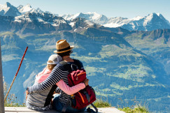 An illustrative photo of two people hugging with a view on mountains.