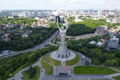 An illustrative photo of a statue in Kyiv with a view of a city in the background.