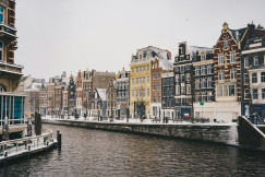 An illustrative photo of buildings covered with snow near a body of water