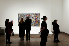 An illustrative photo of a group of people standing in front of a painting