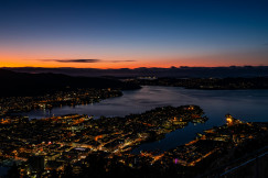 An illustrative photo of a view of a city at night from a hill.