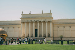 An illustrative photo of people standing near an ancient white building