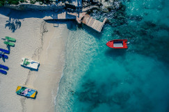 An illustrative photo of a red boat on a body of water near a beach