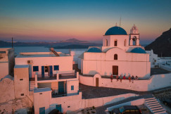 An illustrative photo of white concrete buildings near the sea during sunset.