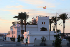 An illustrative photo of a white building with a Spanish flag on top of it