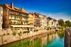 An illustrative photo of white and brown concrete buildings beside river