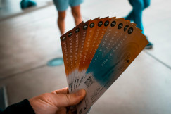 An illustrative photo of a person holding tickets.