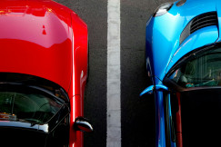 An illustrative photo of blue and red cars on a parking lot.