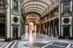 An illustrative photo of people walking through a beautiful hallway building.