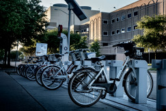 An illustrative photo of electric bicycles parked on the sidewalk.