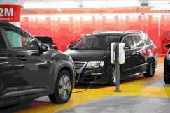 An illustrative photo of a black car charging on a parking lot.