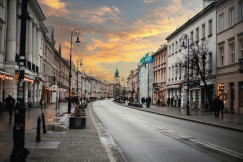 An illustrative photo of a city street with people walking on the sidewalks.