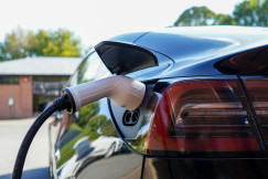 An illustrative photo of a black electric car charging.