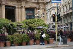 An illustrative photo of a woman walking on sidewalk.
