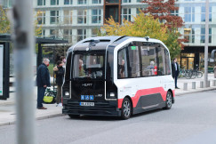 An illustrative photo of a blue and red bus on a road.