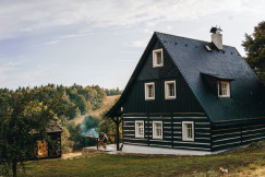 An illustrative photo of a black and white house in the mountains.