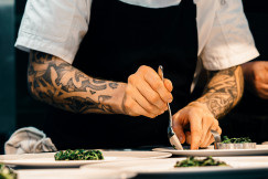 An illustrative photo of a person putting food on a plate.