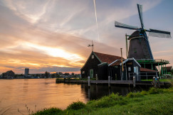 An illustrative photo of a windmill sitting next to a body of water.