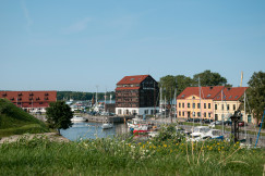 An illustrative photo of red and white houses near a body of water.