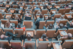 An illustrative photo of a group of people sitting in the auditorium.