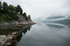 An illustrative photo of a brown rock formation on a lake.