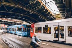 An illustrative photo of a train traveling under a bridge.