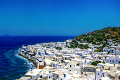 An illustrative photo of white concrete houses near seashore.