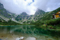 An illustrative photo of green mountains beside lake.