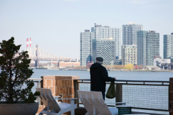 An illustrative photo of a man standing on a balcony.