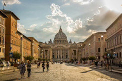 An illustrative photo of people walking on a street in Rome.