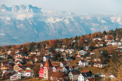An illustrative photo of a town in front of a mountain.