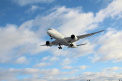 An illustrative photo of a white airplane under blue sky during daytime.
