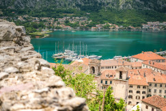 An illustrative photo of a lake surrounded by houses in the mountains.