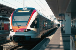 An illustrative photo of a train pulling into a train station next to a platform.