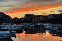 An illustrative photo of boats on a dock during sunset.