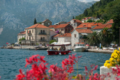 An illustrative photo of a boat floating in a body of water next to a town.