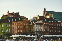 An illustrative photo of a group of people on a street near the brown concrete building.