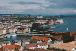An illustrative photo of city buildings near a sea during daytime.