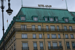 An illustrative photo of a tall building with a green roof and a street light.