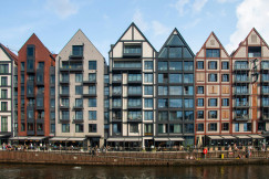An illustrative photo of a row of buildings next to a body of water.