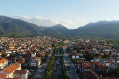 An illustrative photo of a city with mountains in the background.