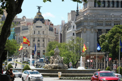 An illustrative photo of cars on a road near a fountain.