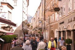 An illustrative photo of people walking on a narrow street during daytime.