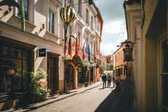 An illustrative photo of a city street with people walking down it.