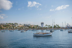 An illustrative photo of a group of boats floating on top of a body of water.