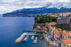 An illustrative photo of city buildings near body of water.