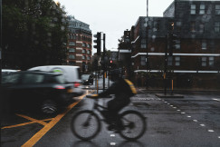 An illustrative photo of a person riding a bike on a city street.
