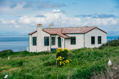 An illustrative photo of a house on a grassy hillside.