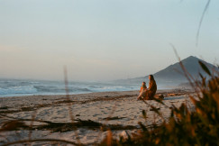 An illustrative photo of people lying on sand.
