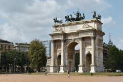 An illustrative photo of a stone arch with statues on top of it.